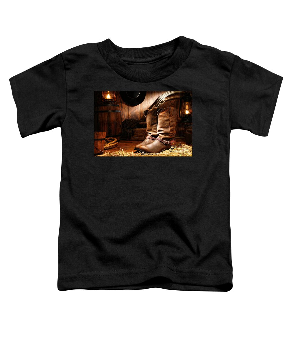 Western Toddler T-Shirt featuring the photograph Cowboy Boots in a Ranch Barn by Olivier Le Queinec