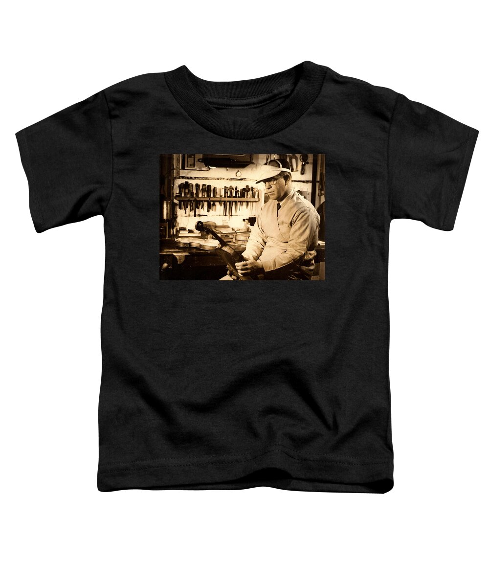 The Violin Maker Toddler T-Shirt featuring the photograph The Violin Maker by Kiki Art
