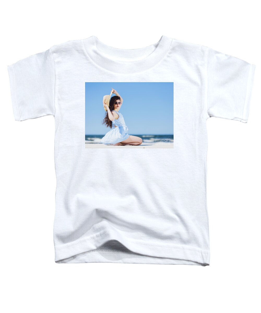 Woman Toddler T-Shirt featuring the photograph Pretty girl sitting on a sandy beach by the blue sea. by Michal Bednarek
