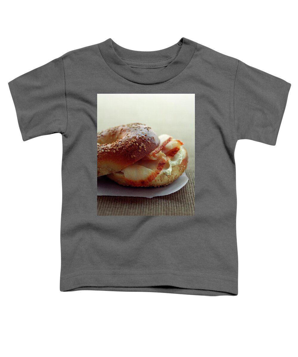 Still Life Toddler T-Shirt featuring the photograph A Sesame Bagel by Romulo Yanes