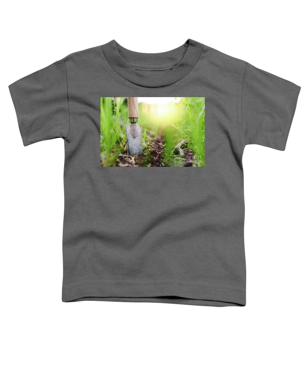 Agricultural Toddler T-Shirt featuring the photograph Gardening shovel in an orchard during the gardener's rest by Joaquin Corbalan