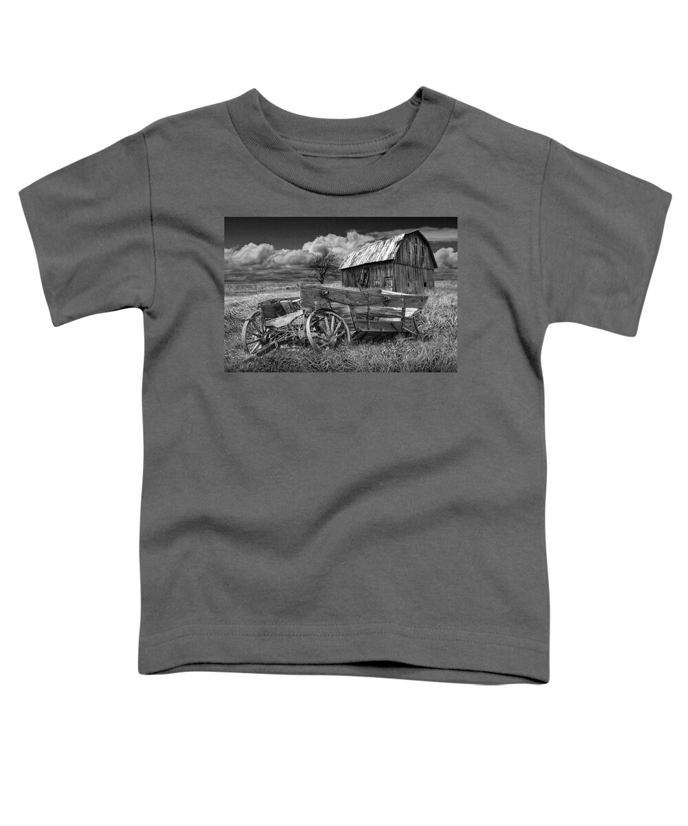 Wagon Toddler T-Shirt featuring the photograph Old Broken Down Wooden Farm Wagon with Barn in Black and White by Randall Nyhof
