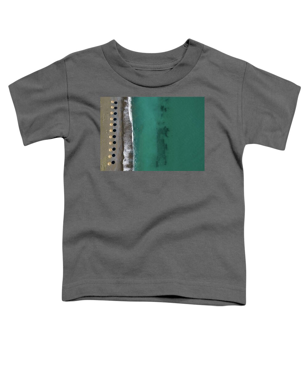 Summertime Toddler T-Shirt featuring the photograph Aerial view from a flying drone of beach umbrellas in a row on an empty beach #2 by Michalakis Ppalis