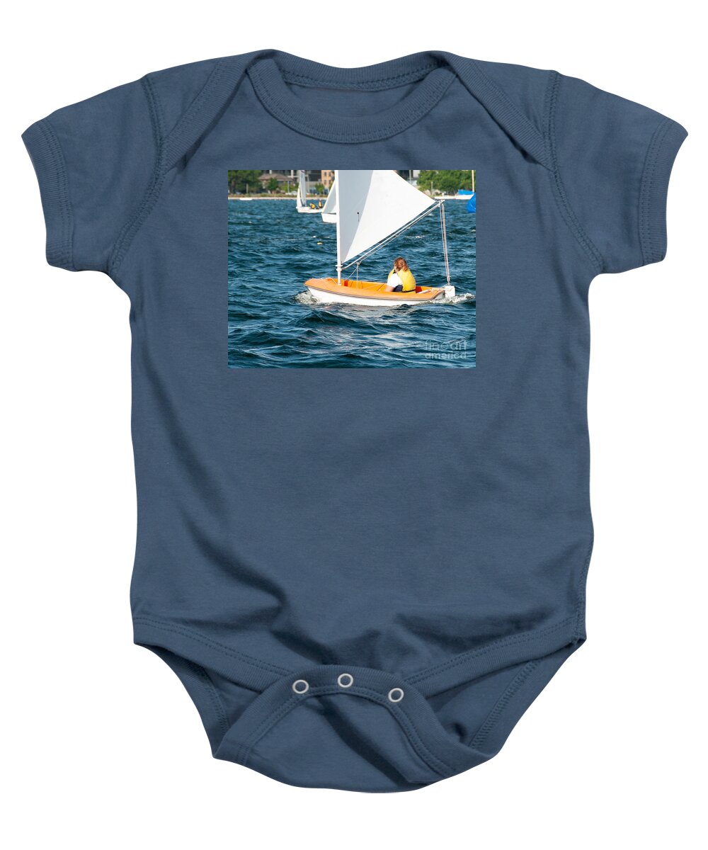 Csne57 Baby Onesie featuring the photograph A female sailor Sailing small sailboat solo on an inland waterwa by Geoff Childs