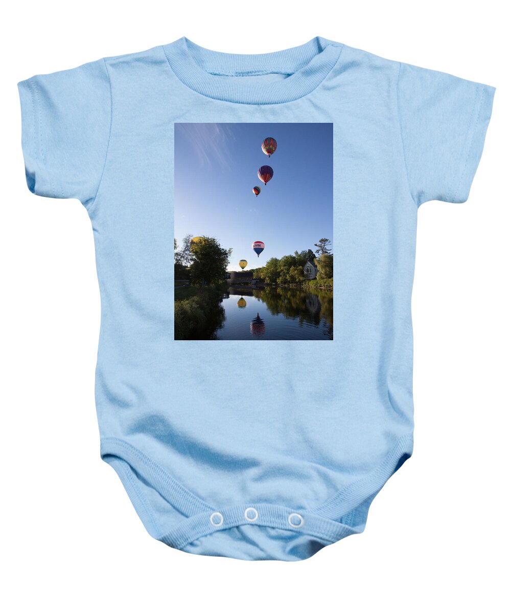 Quechee Covered Bridge Baby Onesie featuring the photograph Hot air balloons playing follow the leader by Jeff Folger