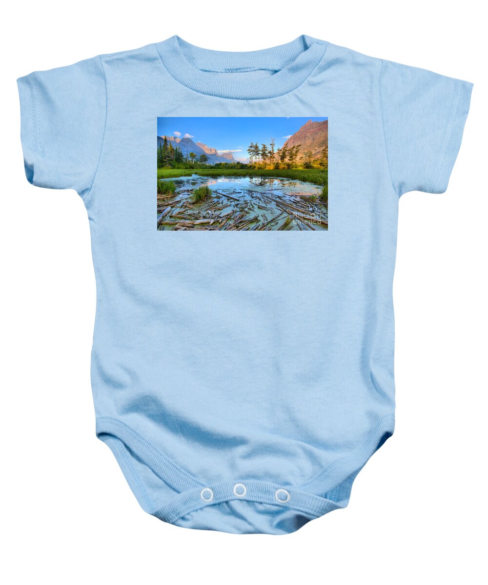 St Mary Lake Baby Onesie featuring the photograph Pink Peaks Over Driftwood by Adam Jewell
