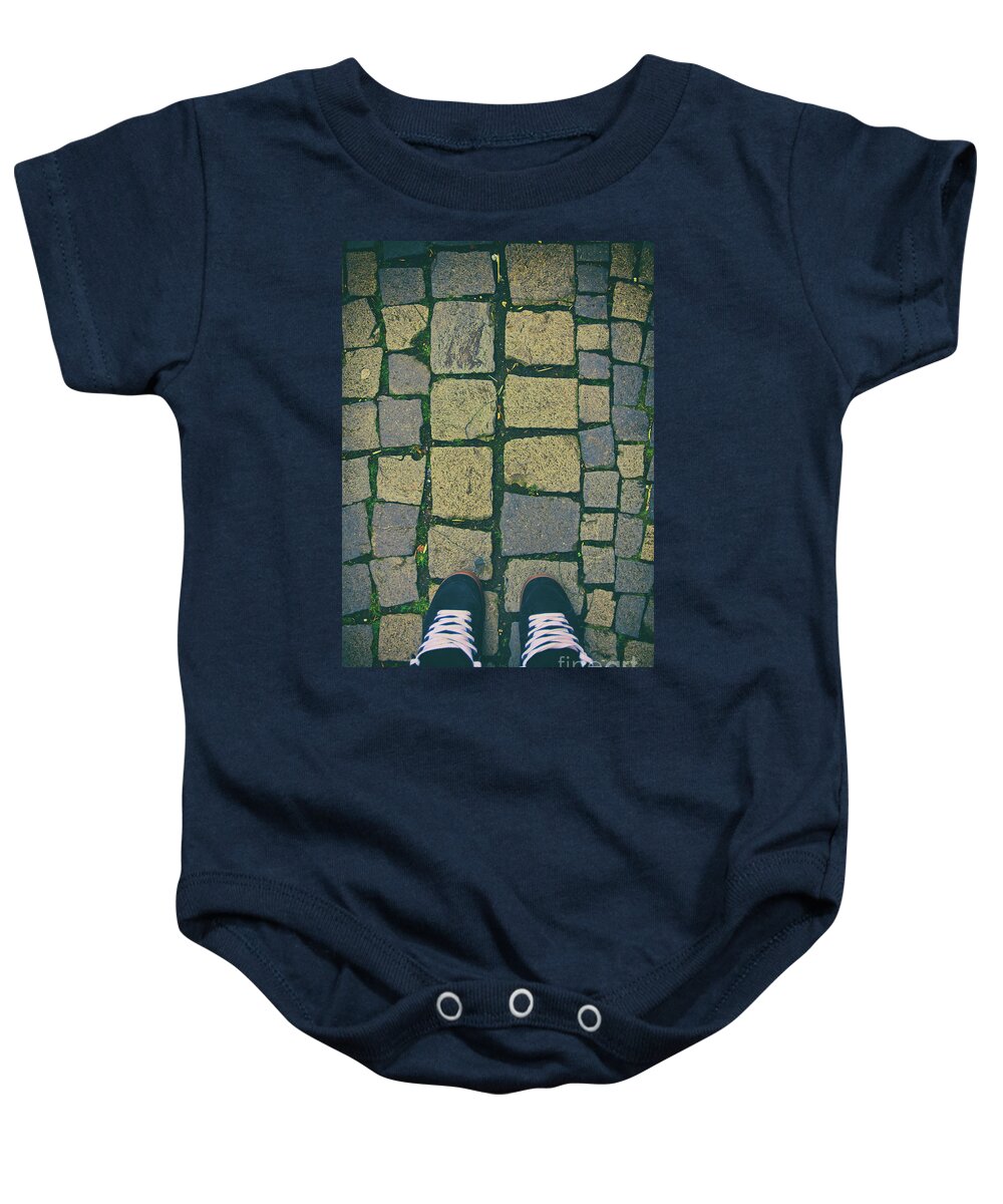 Sneakers Baby Onesie featuring the photograph Feet in urban sneakers on cobblestones by Mendelex Photography