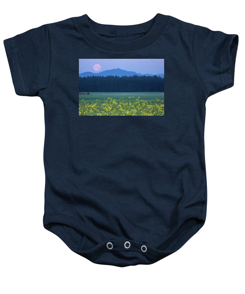 Full Baby Onesie featuring the photograph Full Moon setting over mountains and rapeseed by Ian Middleton