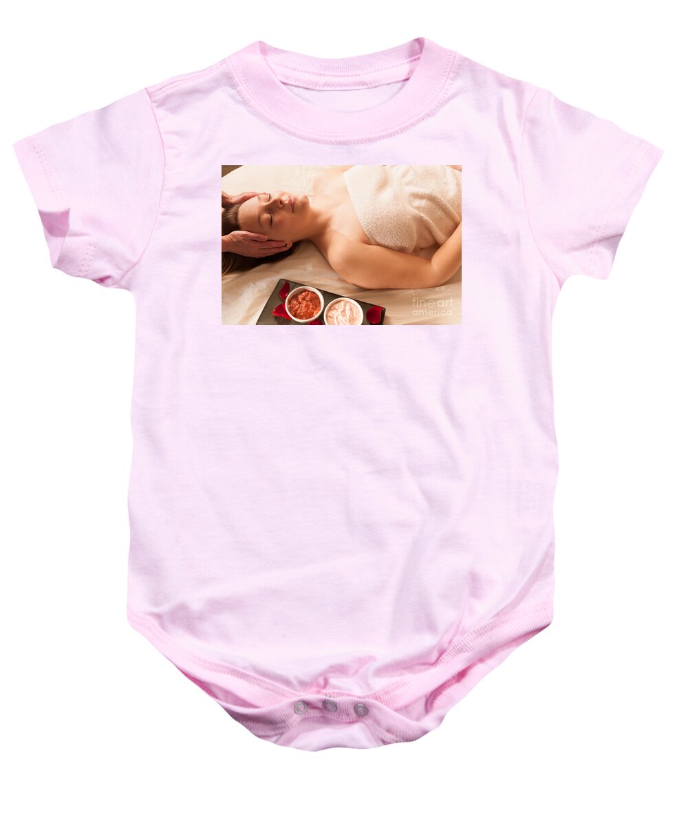 Attractive Baby Onesie featuring the photograph Beautiful woman receiving a massage in a spa. #1 by Don Landwehrle