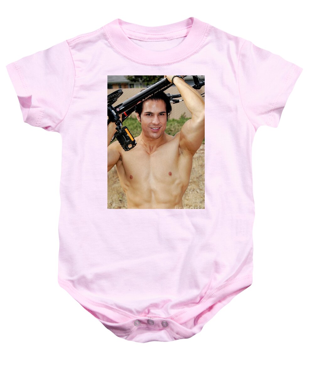 Bicycle Baby Onesie featuring the photograph A hot, attractive cyclist raises his bike above his head. by Gunther Allen