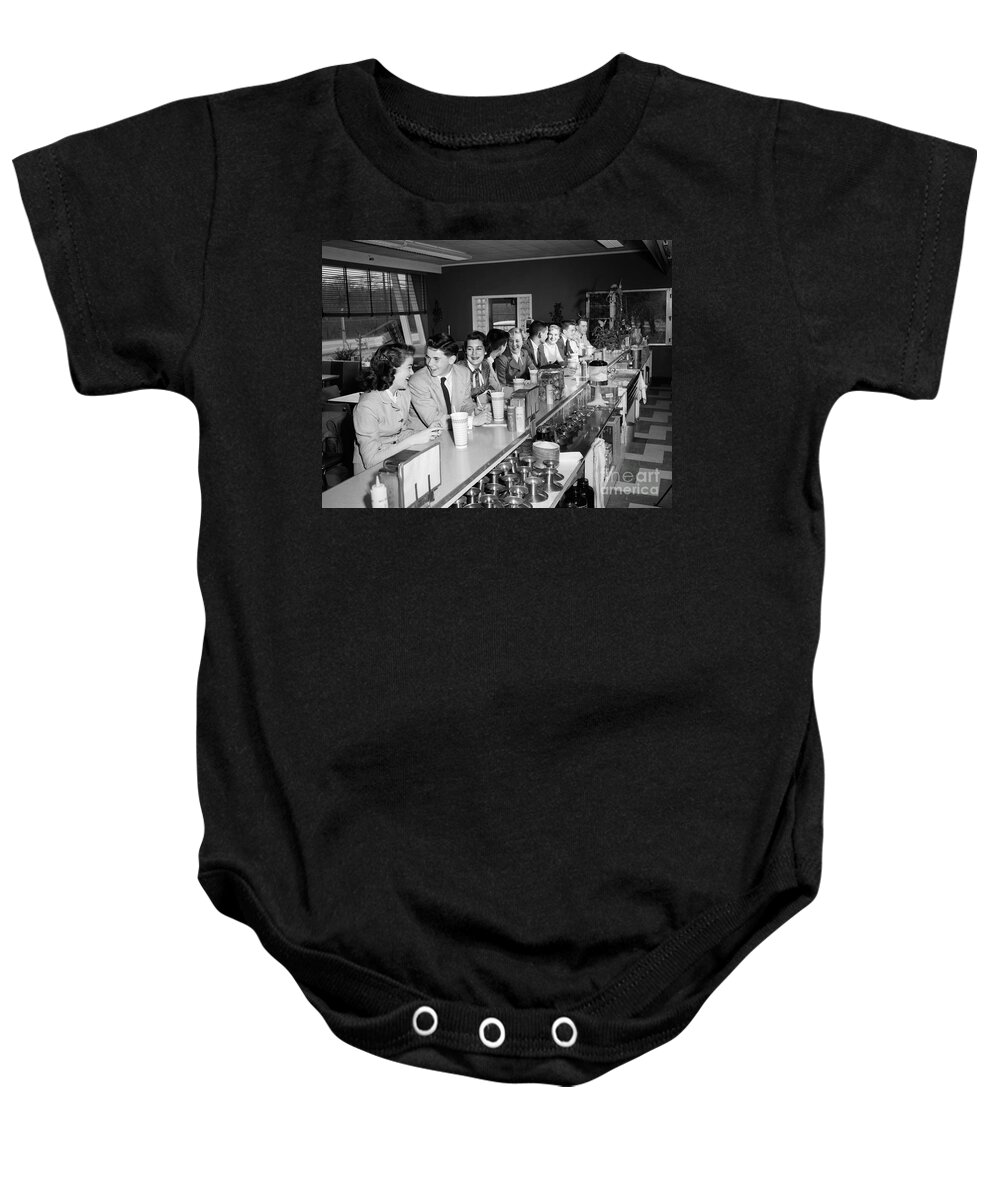 1950s Baby Onesie featuring the photograph Teens At Soda Fountain Counter, C.1950s by H. Armstrong Roberts/ClassicStock