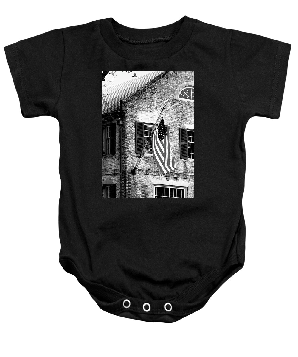 Colonial Baby Onesie featuring the photograph US Flag in Colonial Williamsbug by Emanuel Tanjala