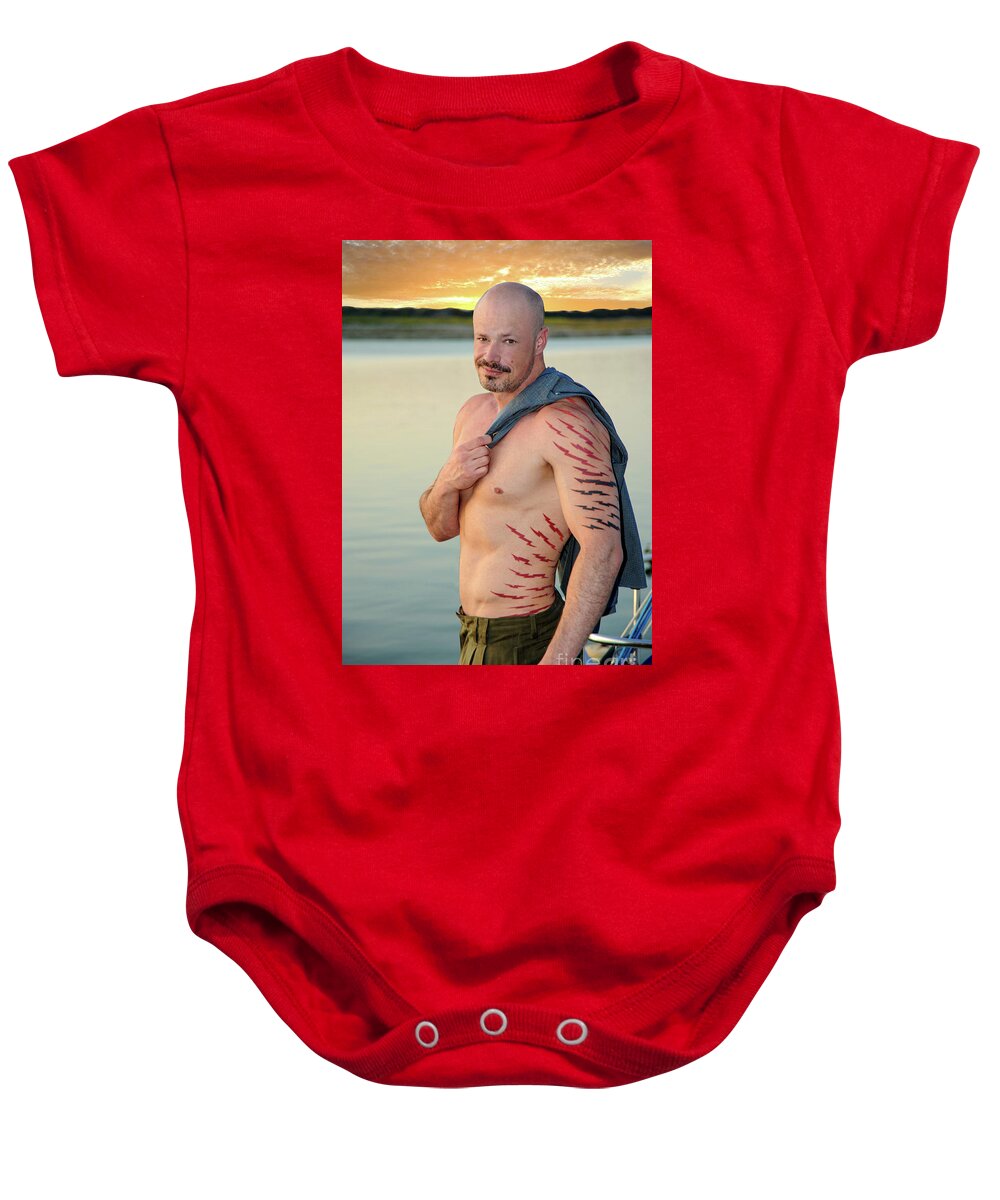 Body Baby Onesie featuring the photograph Bald headed model poses by the lake at sunset. by Gunther Allen