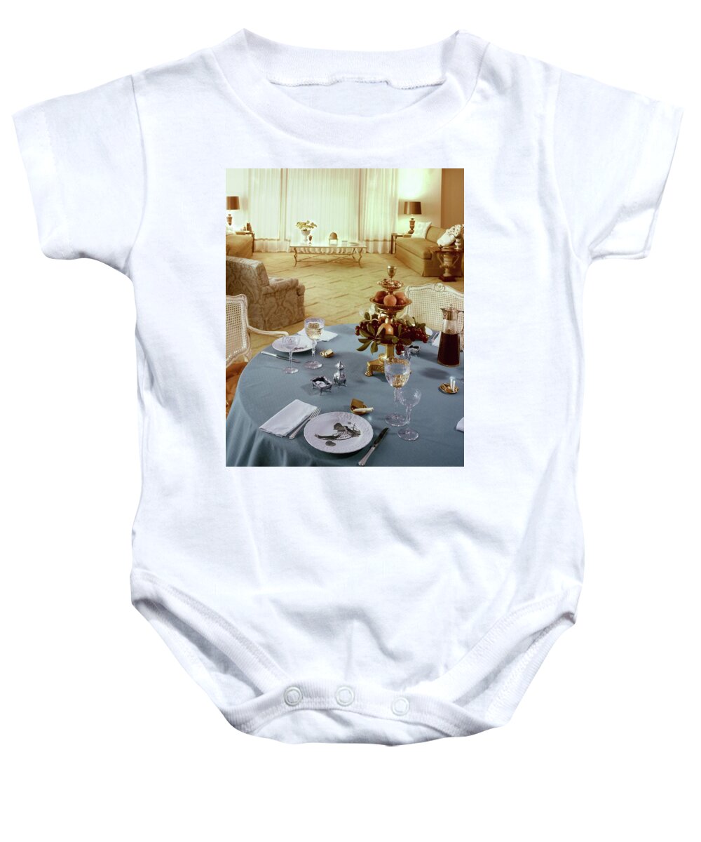 Indoors Baby Onesie featuring the photograph A Dining Room With A Blue Tablecloth And Ornate by Wiliam Grigsby