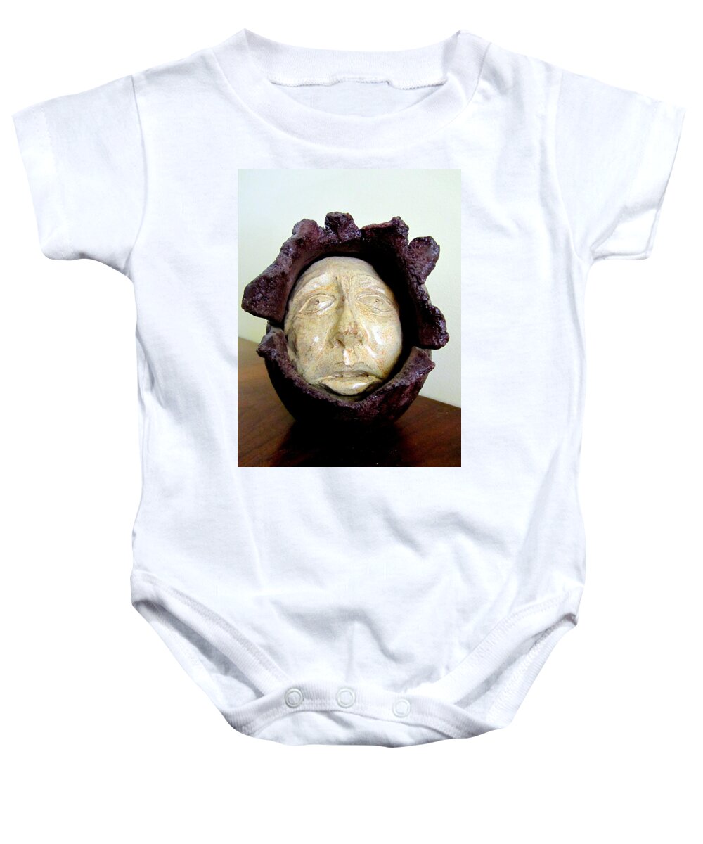 Emerging Baby Onesie featuring the sculpture Emerging white pale face born out of a brown purple thing eyes nose mouth by Rachel Hershkovitz