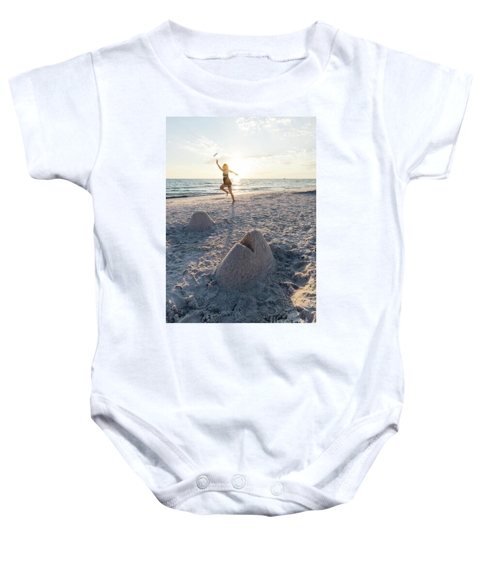 Anna Maria Island Baby Onesie featuring the photograph A woman catches a flying disk near a sand sculpture of a fish he by William Kuta