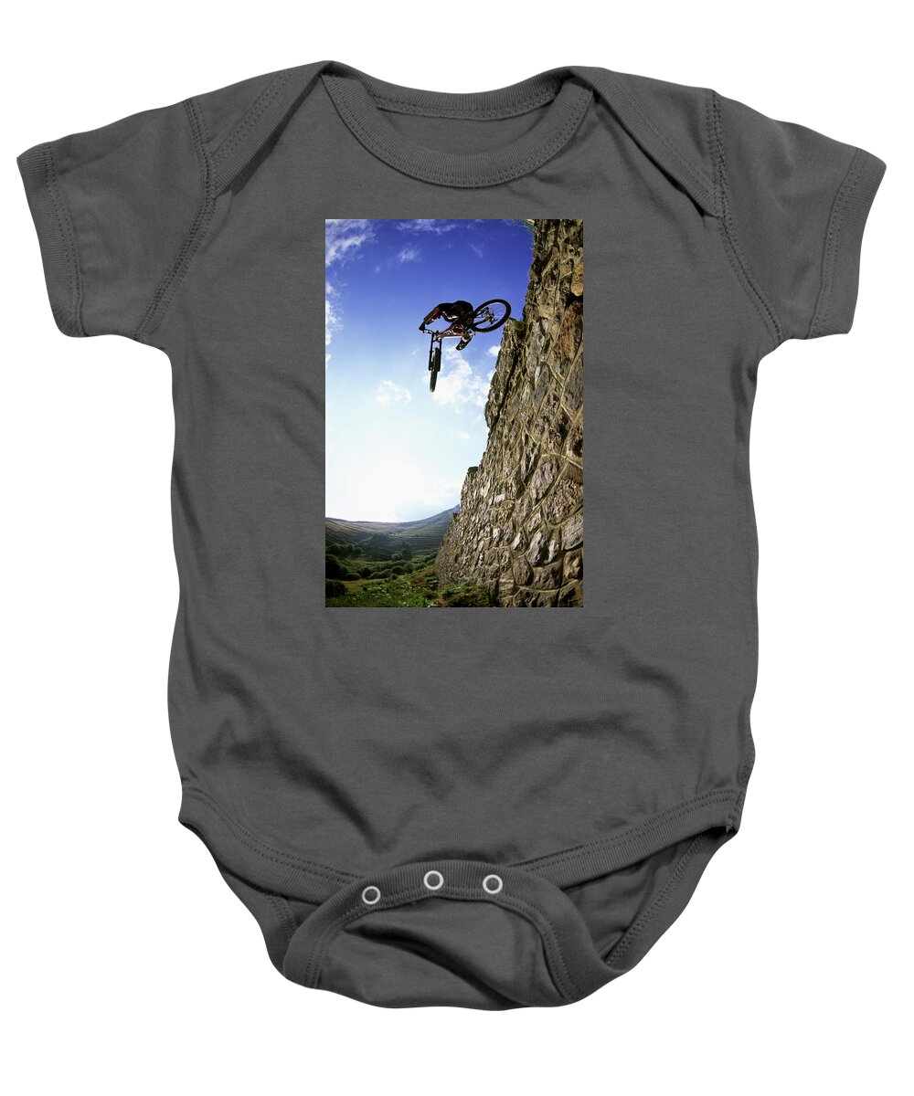 Action Baby Onesie featuring the photograph Biker Making Wall Jump In France by Scott Markewitz