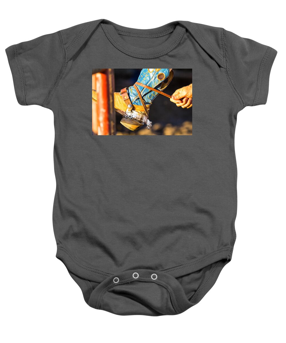 Steven Bateson Baby Onesie featuring the photograph Rodeo Boot Tie Down by Steven Bateson