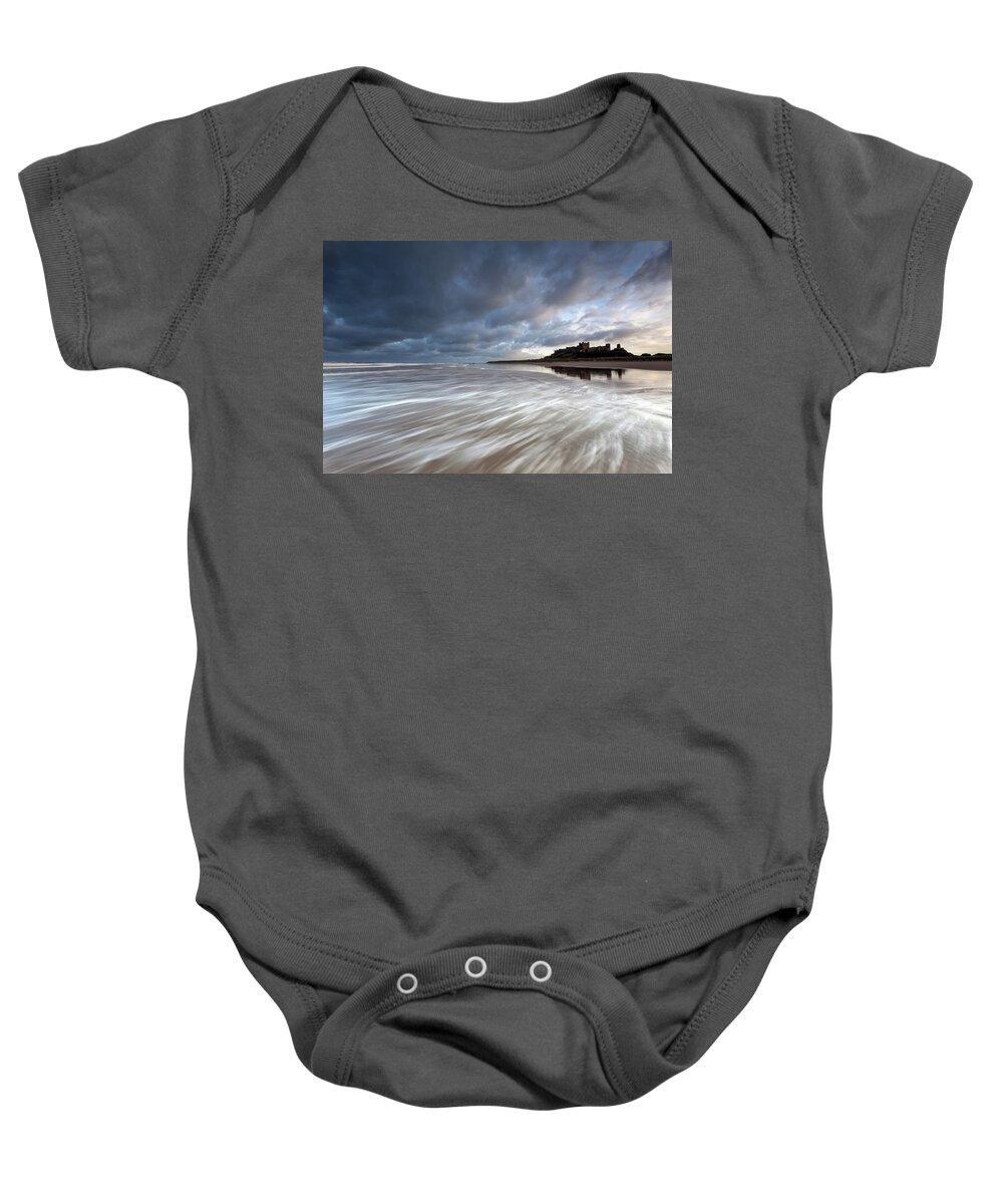 Bamburgh Castle Baby Onesie featuring the photograph Bamburgh Castle at high tide in the surf by Anita Nicholson