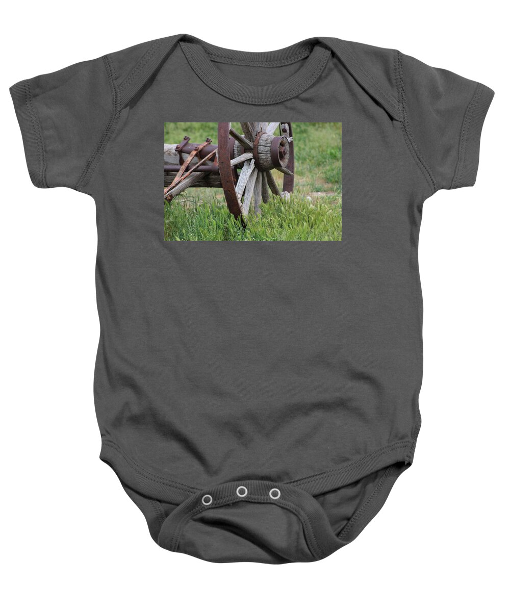 Wagon Wheel Baby Onesie featuring the photograph Closeup Vintage Wooden Wagon Wheel in Grass by Colleen Cornelius