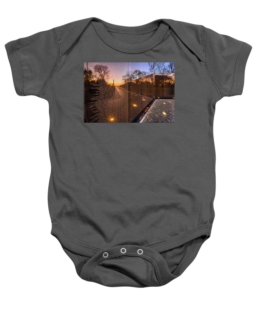 Sunrise Baby Onesie featuring the photograph Sunrise reflections at the Vietnam Veterans Memorial by Robert Miller