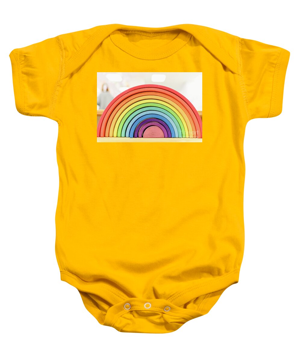 Arrangement Baby Onesie featuring the photograph Colorful Waldorf wooden rainbow in a montessori teaching pedagogy classroom. by Joaquin Corbalan