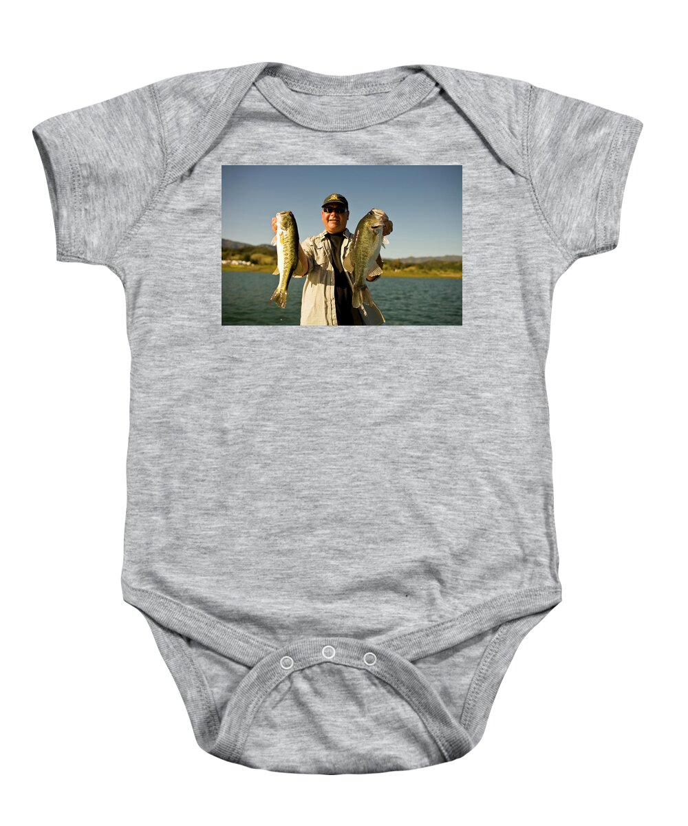 40-44 Years Baby Onesie featuring the photograph A Man Holds Up His Catch Proudly by Jay Reilly