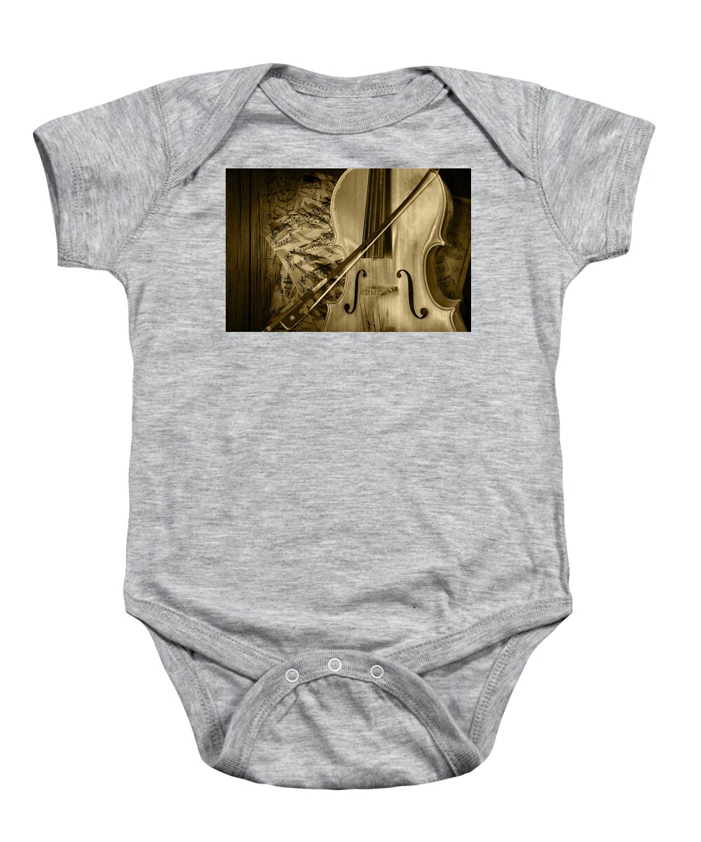 Cello Baby Onesie featuring the photograph Cello Stringed Instrument with Sheet Music and Bow in Sepia by Randall Nyhof