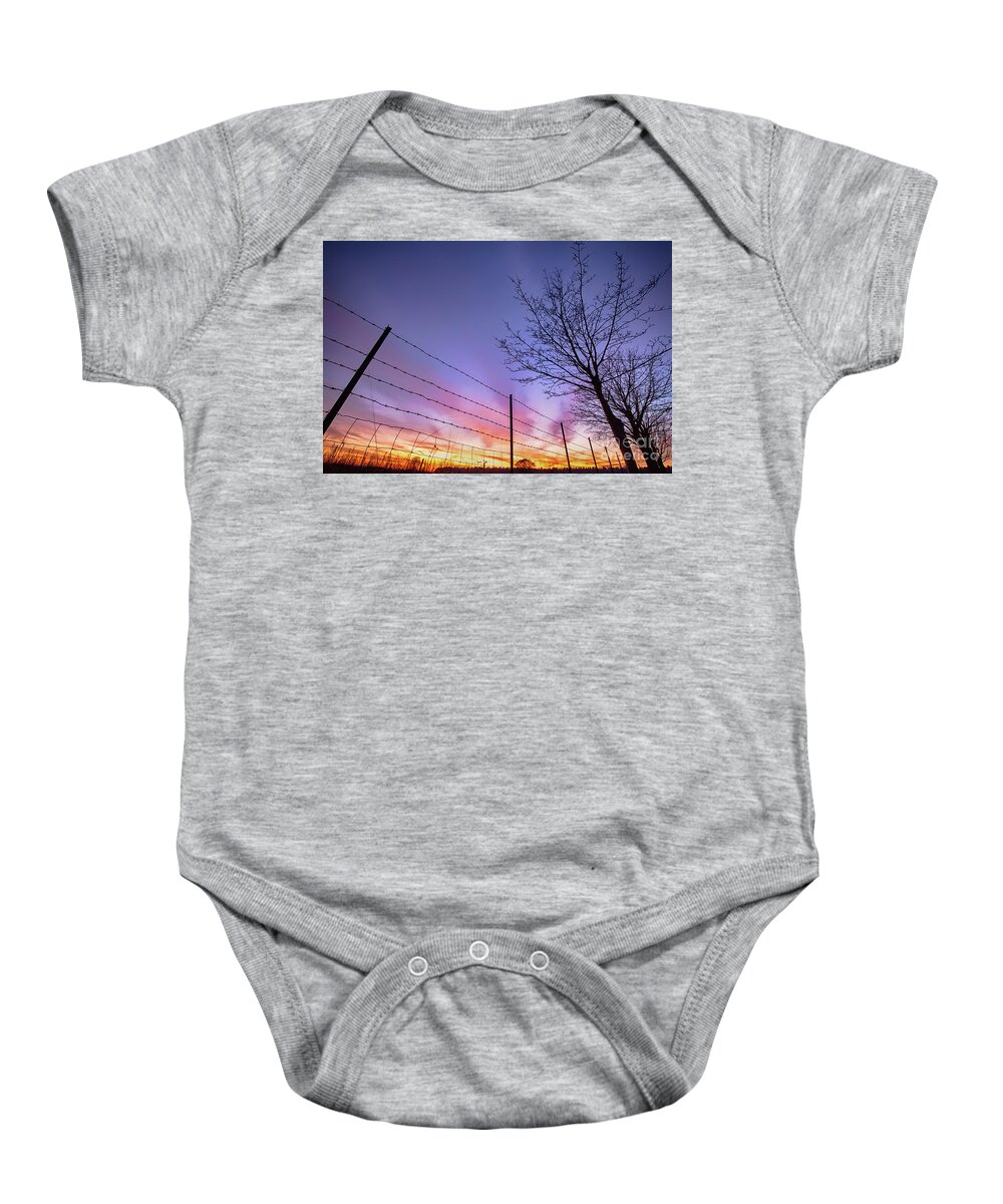 Sunset Baby Onesie featuring the photograph Fiery Norfolk sunset viewed through barbed fence by Simon Bratt