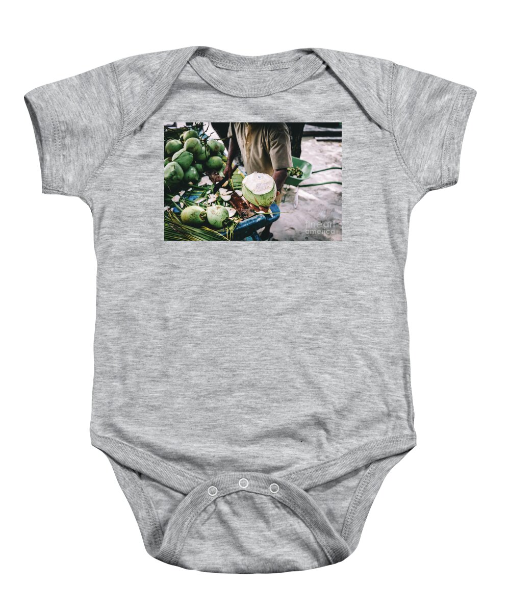 Man Baby Onesie featuring the photograph Man handing in a green coconut. Traditional local agriculture. by Michal Bednarek
