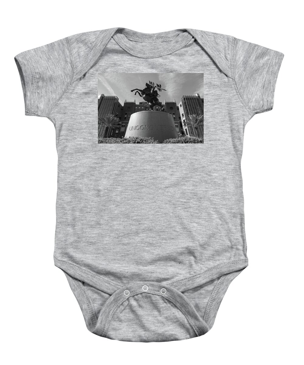 Florida State Baby Onesie featuring the photograph Unconquered statue in front of Doak Campbell Stadium at Florida State University in black and white by Eldon McGraw