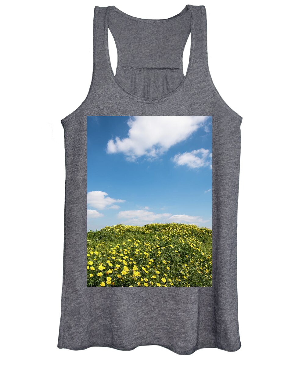 Flowers Women's Tank Top featuring the photograph Field with yellow marguerite daisy blooming flowers against and blue cloudy sky. Spring landscape nature background by Michalakis Ppalis