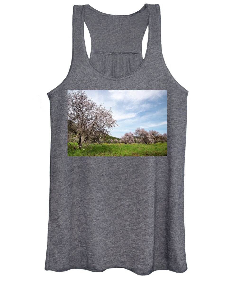 Spring Women's Tank Top featuring the photograph Almond trees bloom in spring against blue sky. by Michalakis Ppalis