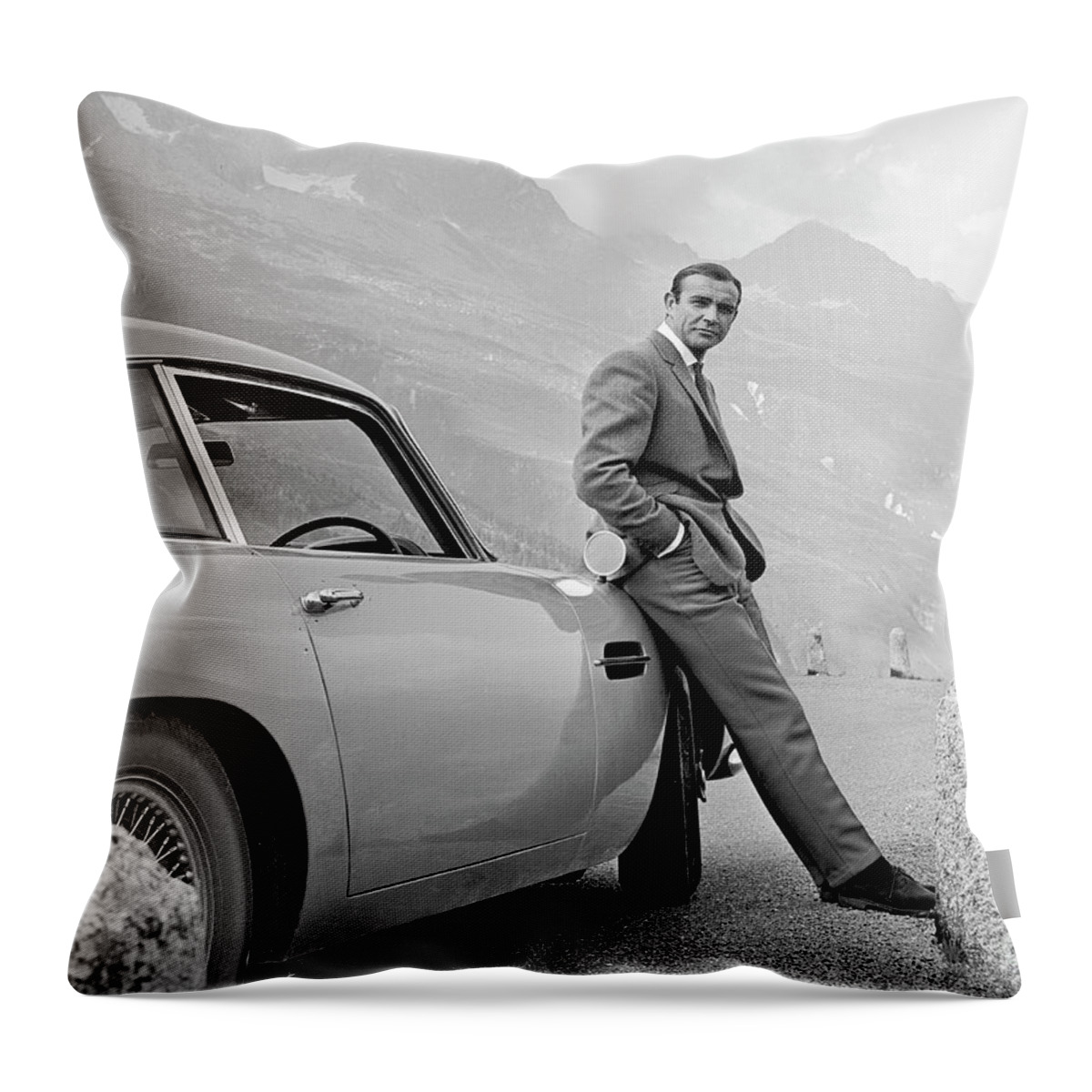 James Bond Throw Pillow featuring the photograph James Bond Coolly Leaning on His Aston Martin by Doc Braham