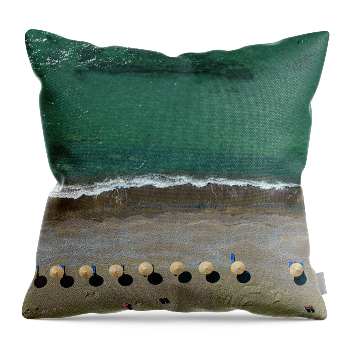 Summertime Throw Pillow featuring the photograph Aerial view from a flying drone of beach umbrellas in a row on an empty beach with braking waves. by Michalakis Ppalis