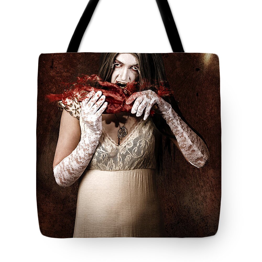 Blood Tote Bag featuring the photograph Zombie vampire woman eating human hand #1 by Jorgo Photography
