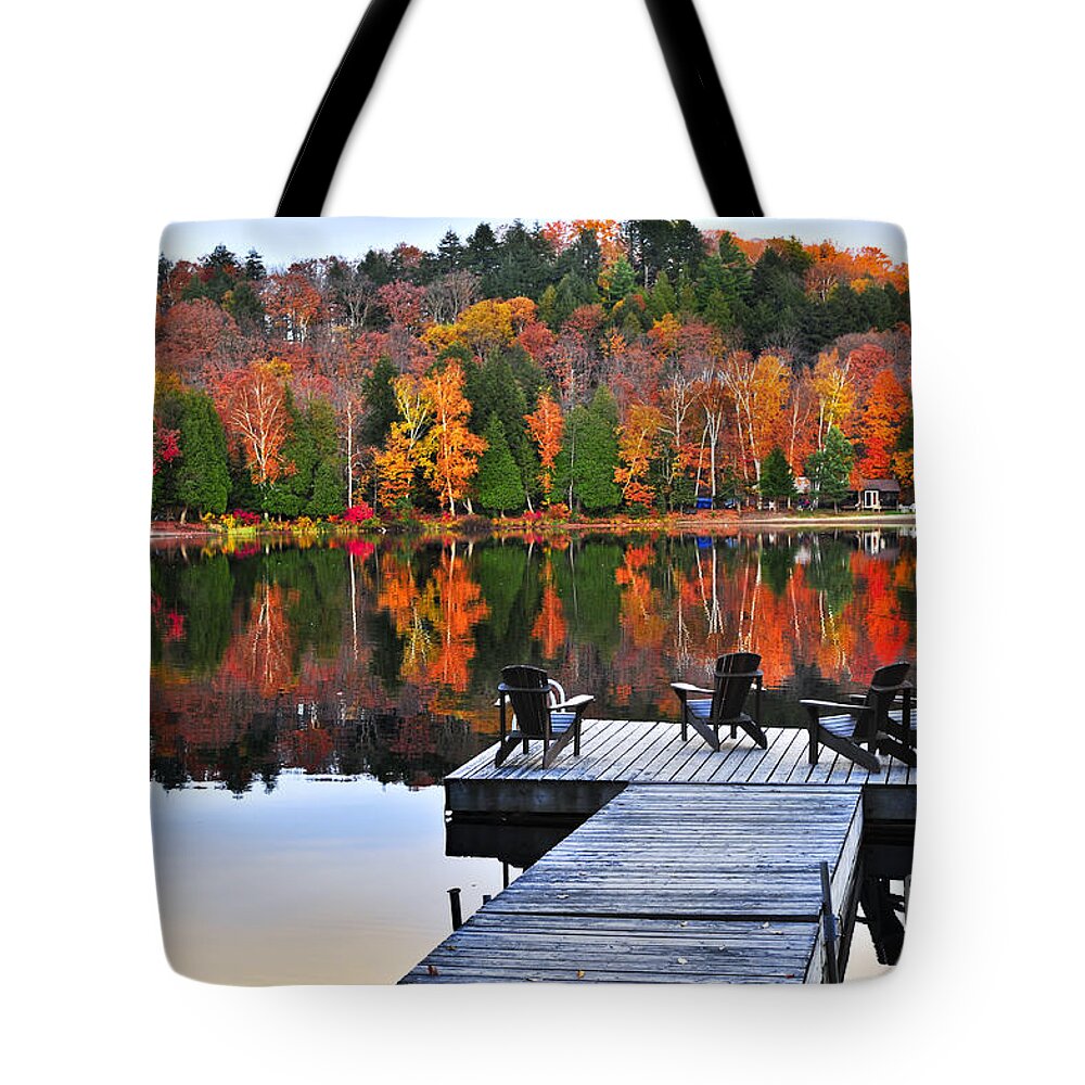 Lake Tote Bag featuring the photograph Wooden dock with chairs on autumn lake by Elena Elisseeva