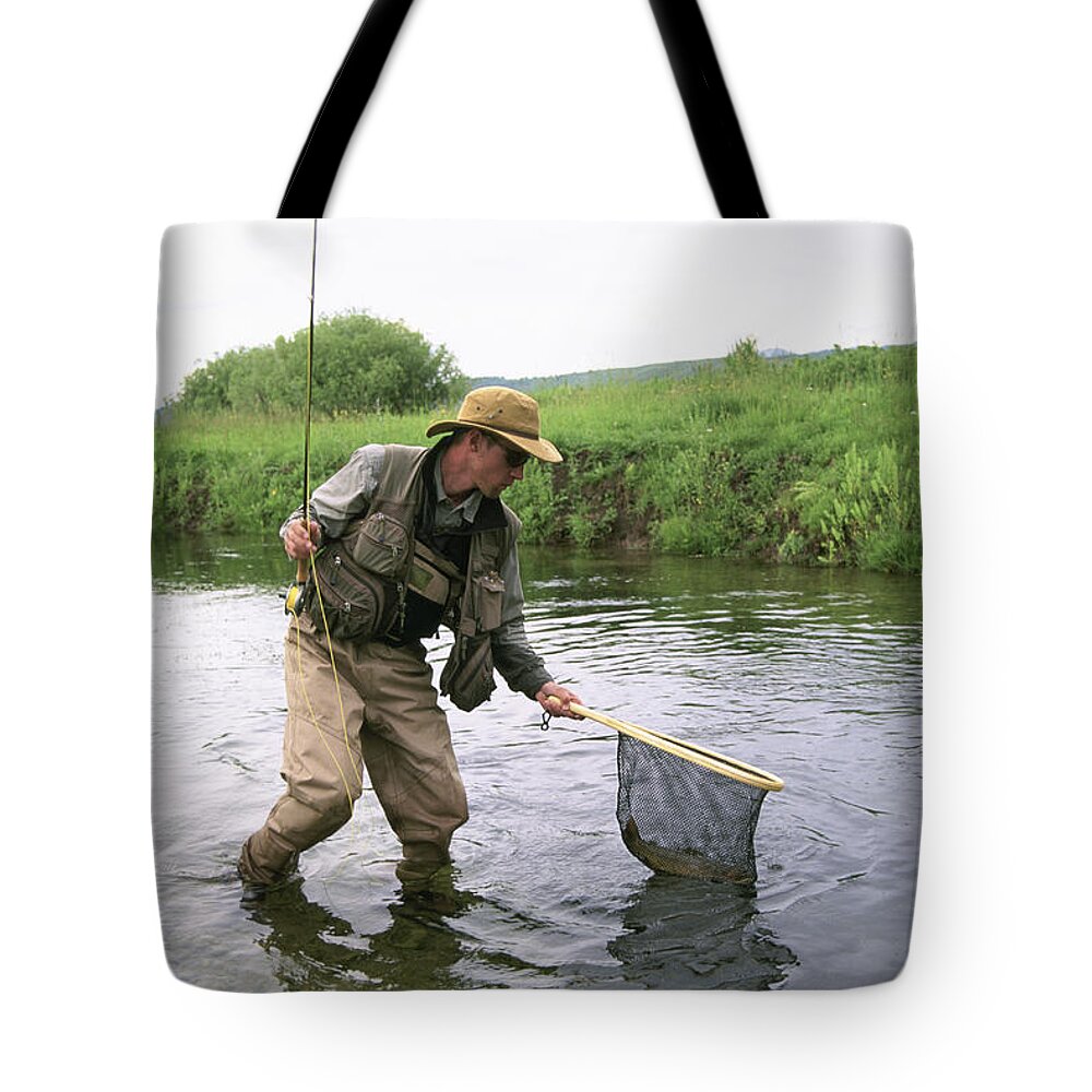 https://render.fineartamerica.com/images/rendered/default/tote-bag/images-medium-5/a-fly-fisherman-lands-a-wild-trout-tom-montgomery.jpg?&targetx=0&targety=-188&imagewidth=763&imageheight=1140&modelwidth=763&modelheight=763&backgroundcolor=FAF9FB&orientation=0&producttype=totebag-18-18