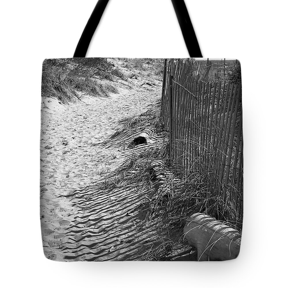 Beach Retaining Fence Tote Bag featuring the photograph A Stroll In The Sand by Jeff Folger