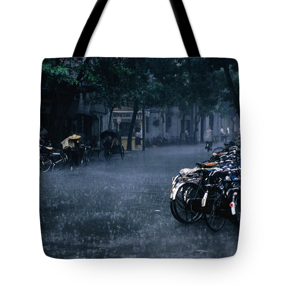 Season Tote Bag featuring the photograph A Tropical Storm Rains Down On Bicycles by Dallas Stribley