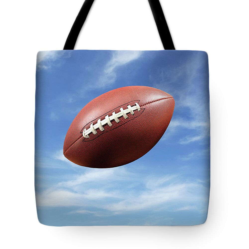 American Football Tote Bag featuring the photograph American Football Flying Mid-air by Steven Puetzer