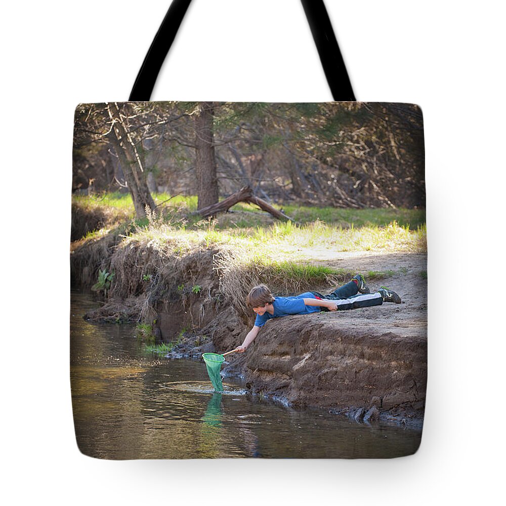 Child Tote Bag featuring the photograph Boy With Net Playing In A Stream by Stephen Simpson