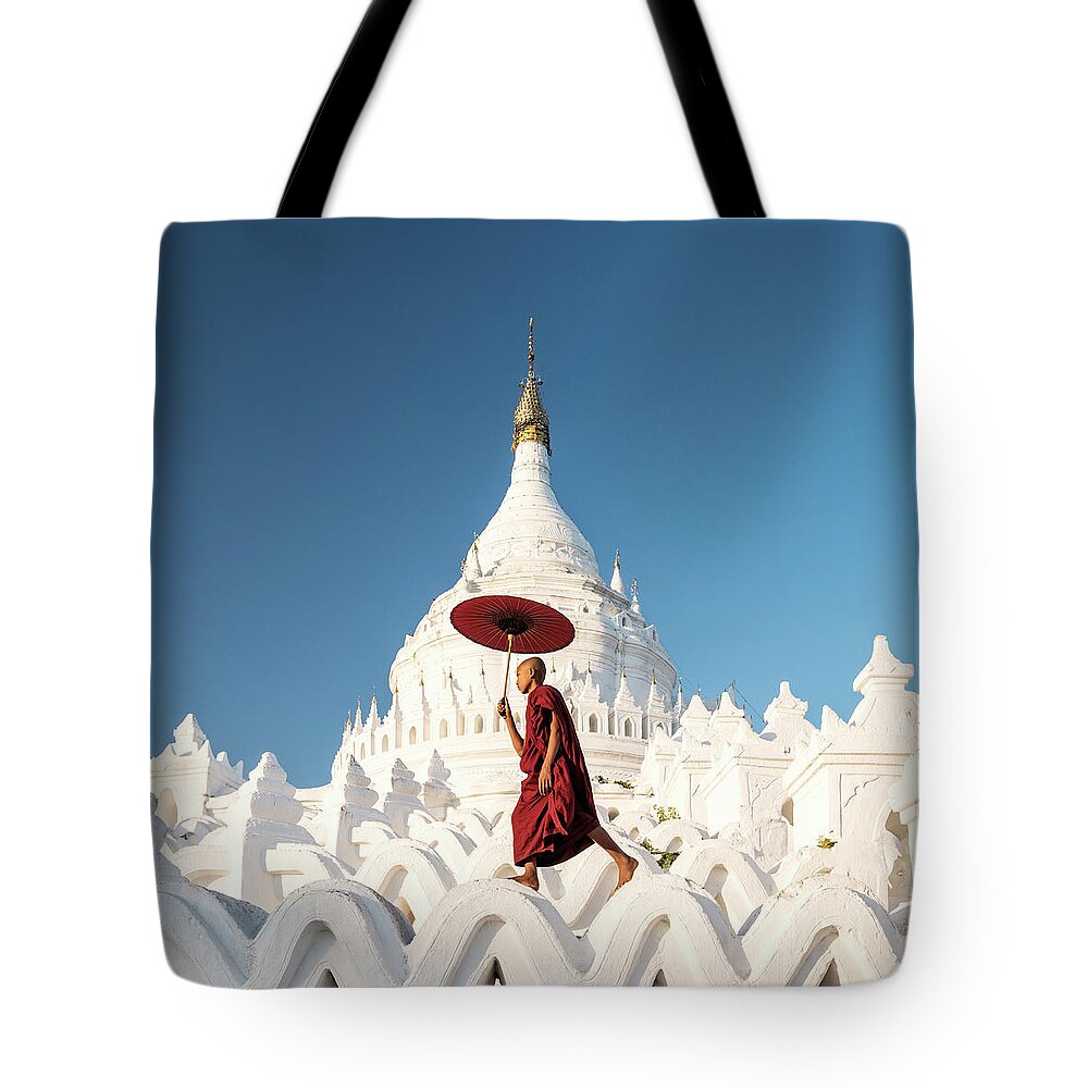 Pagoda Tote Bag featuring the photograph Buddhist Monk Walking Across Arches Of by Martin Puddy