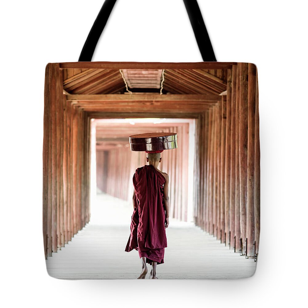 Adolescence Tote Bag featuring the photograph Buddhist Monk Walking Along Temple by Martin Puddy