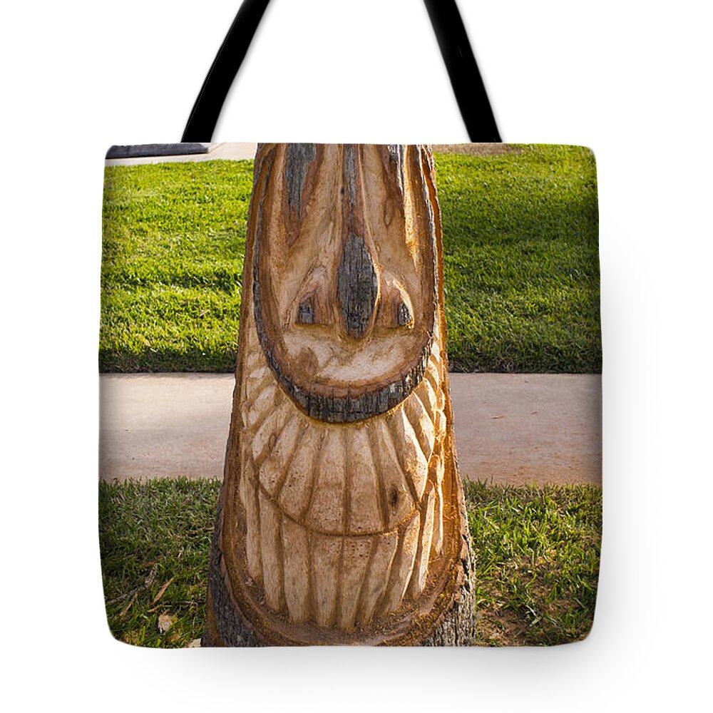 Carving a happy Tiki from a Palm Tree Stump Tote Bag