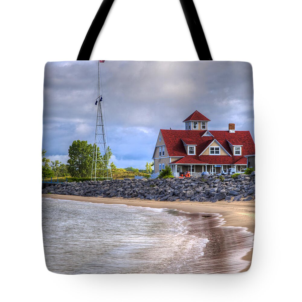 American Tote Bag featuring the photograph Coast Guard Station in Muskegon by Debra and Dave Vanderlaan