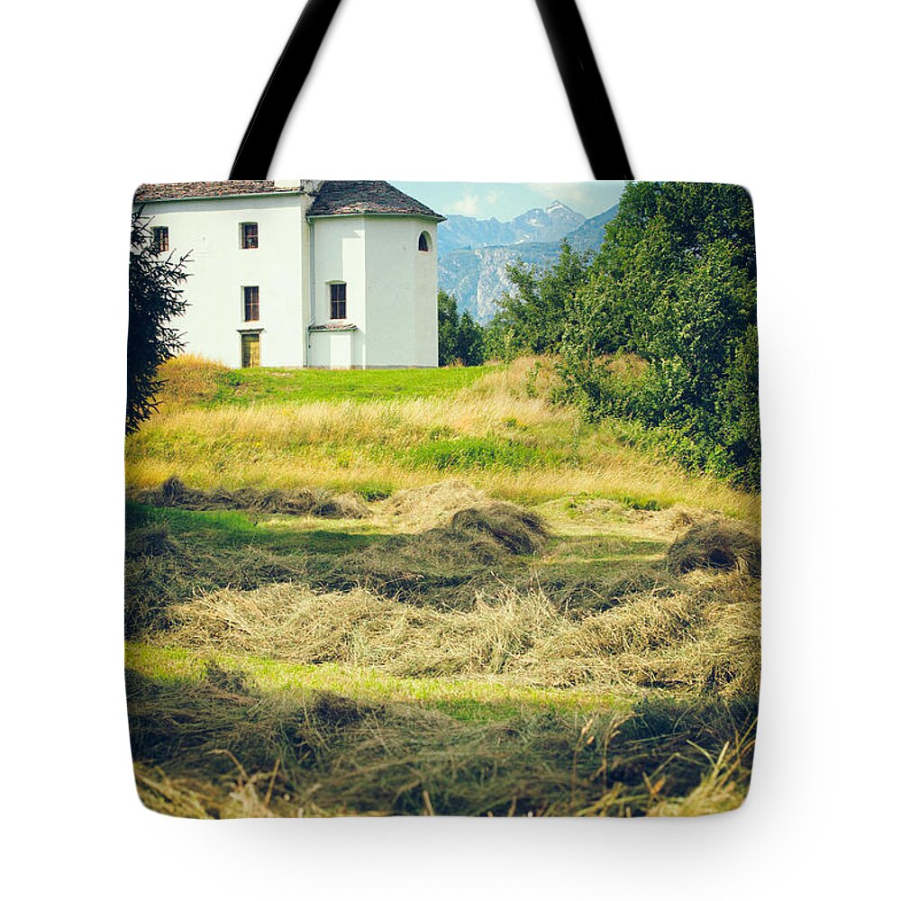 Alpine Tote Bag featuring the photograph Country church with hay by Silvia Ganora