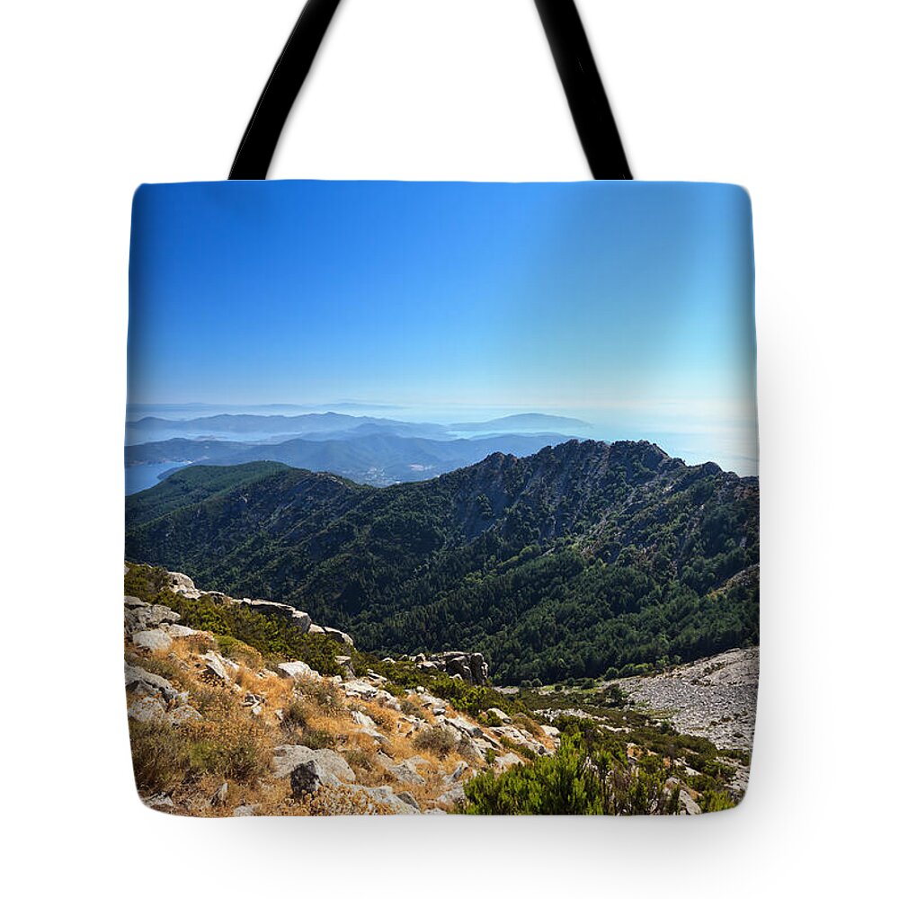 Elba Tote Bag featuring the photograph Elba island against the sun by Antonio Scarpi