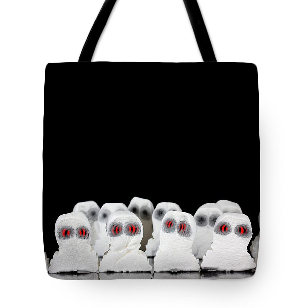 Black Tote Bag featuring the photograph Evil white ghosts in a crowd with black space by Simon Bratt