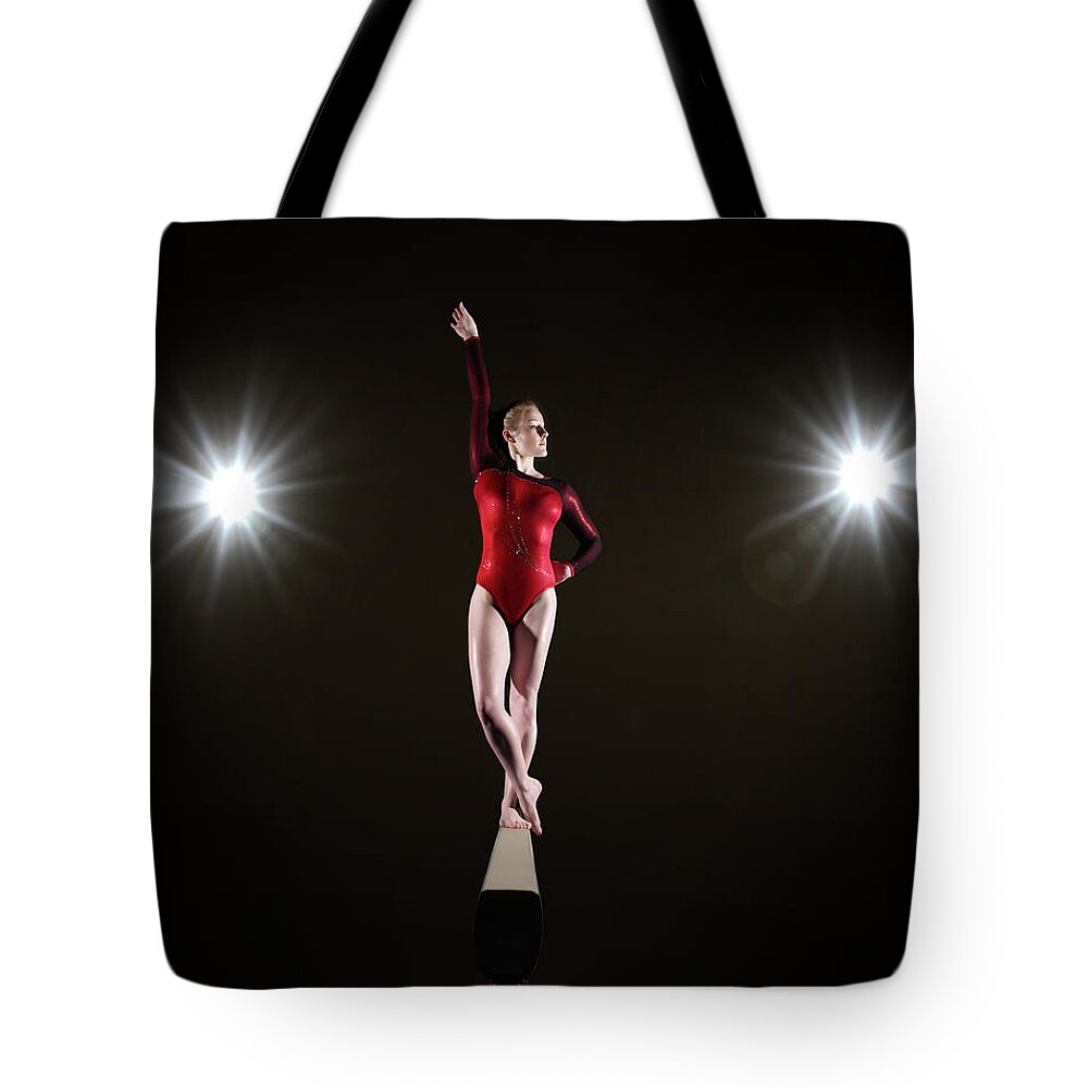 Human Arm Tote Bag featuring the photograph Female Gymnast On Balancing Beam by Mike Harrington